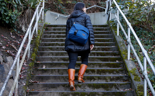 A person walking up some stairs with a Maker's Bag.